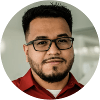 A Hispanic male in his late 20's with glasses, trimmed facial hair, and a red shirt.