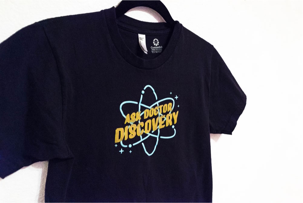 The Ask Dr. Discovery logo on a dark blue t-shirt for the team to wear at usability testing events at the museums.