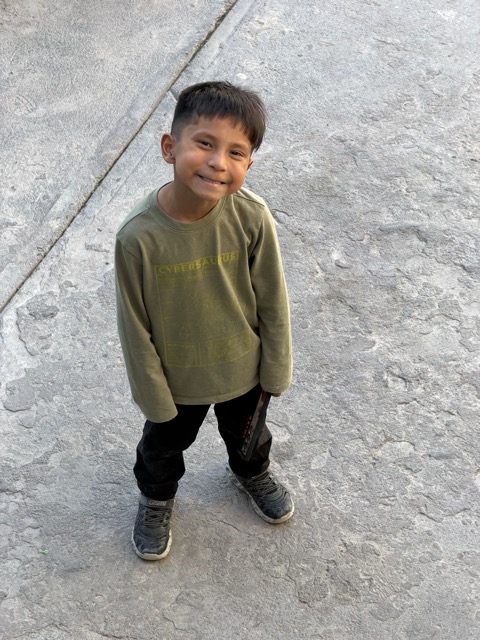 Child standing in front of a photo wall