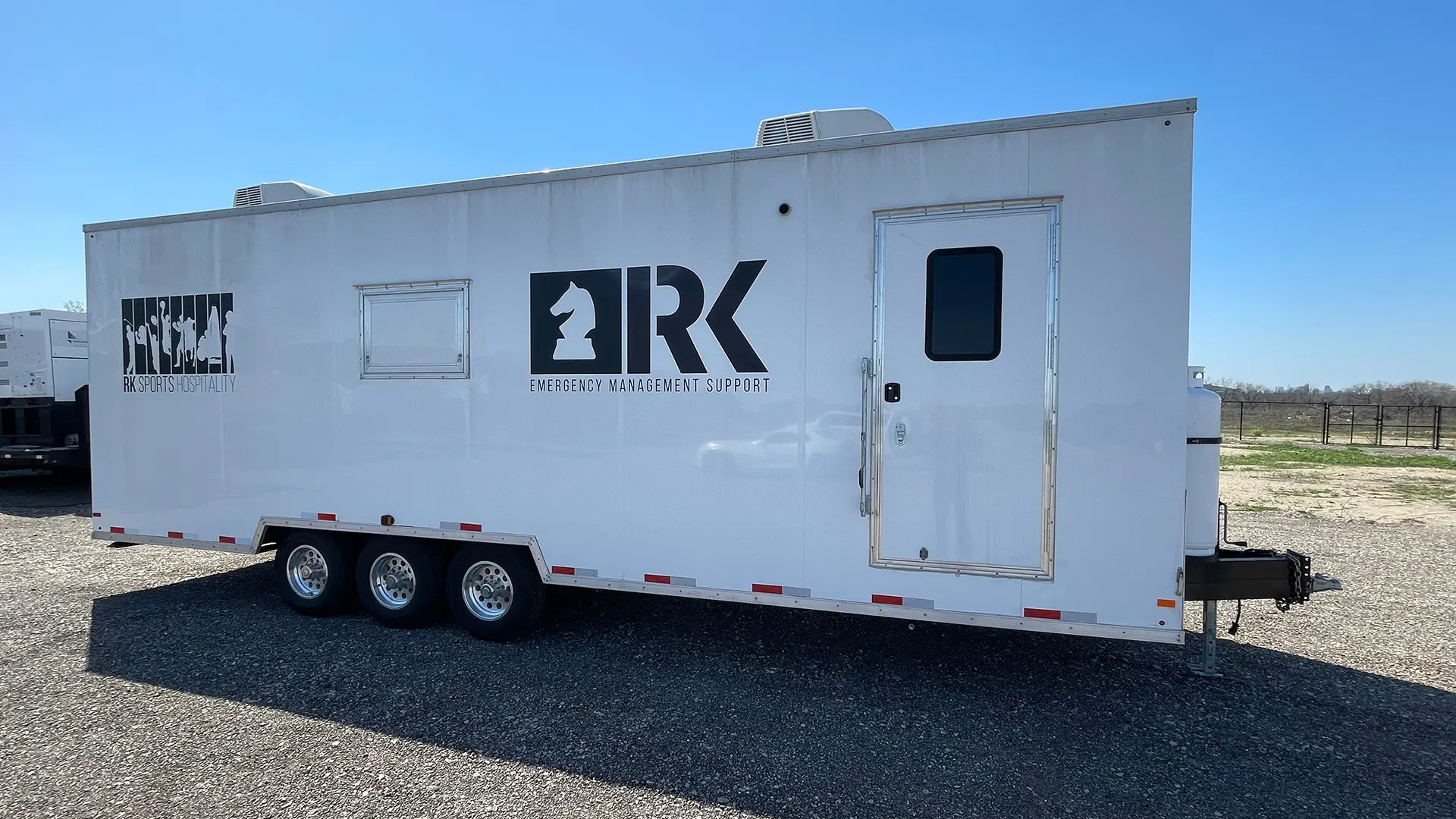 Exterior of 28 foot Mobile Dishwashing Trailer. Logo of RK Emergency Management Services on the side. 