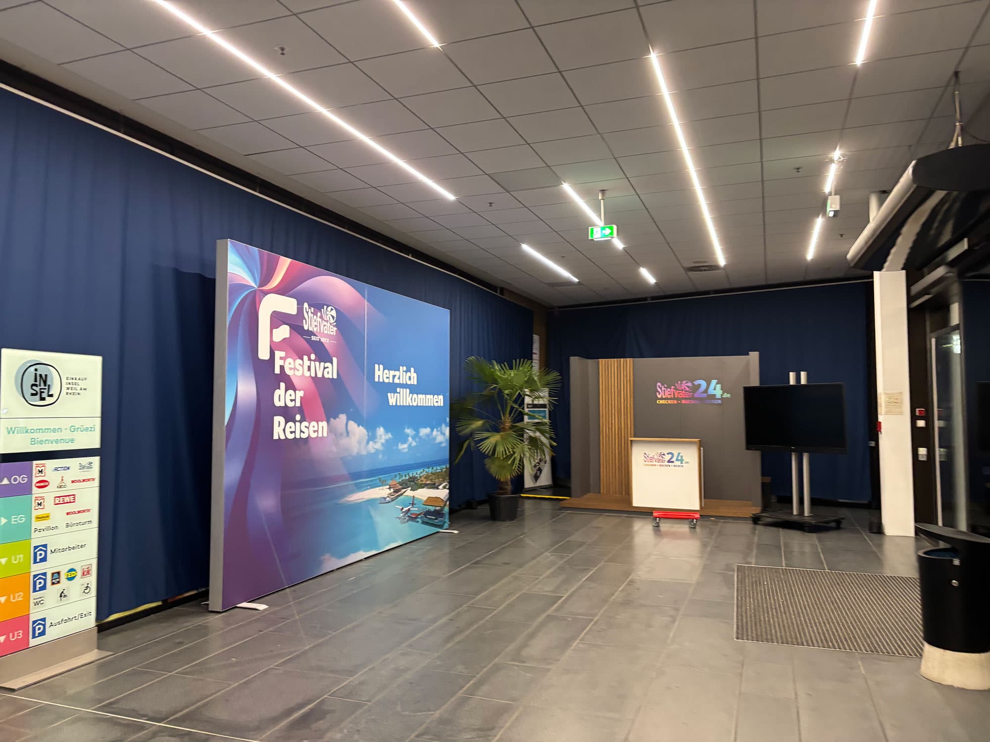 Bedruckte Stoffwände im Empfangsbereich der Hausmesse „Festival der Reisen“ 2025