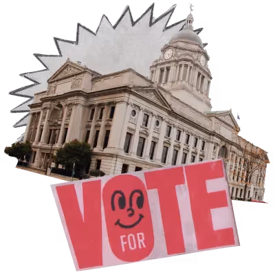 a paper cutout with the word "VOTE" in red, with a smiley face inside the letter o