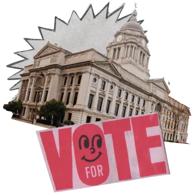 a paper cutout with the word "VOTE" in red, with a smiley face inside the letter o