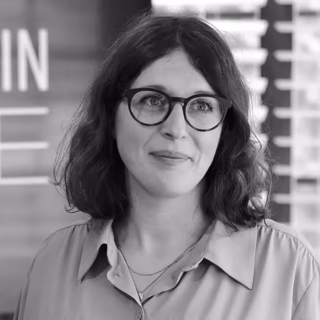 Georgia Rakusen headshot - black and white photo of woman with glasses and shoulder-length brown hair in white collared shirt