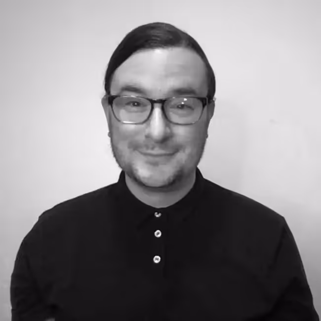 jake burghardt headshot - man with short dark hair and glasses in black-and-white photo