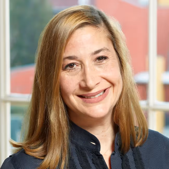 michele ronsen headshot - woman with blonde hair smiling against blurred background