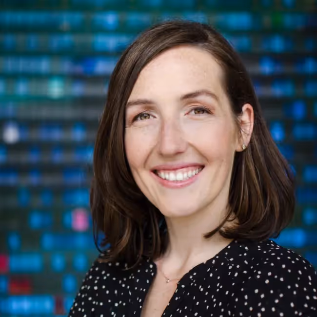 marieke mccloskey headshot - woman with shoulder-length dark hair against a blue background