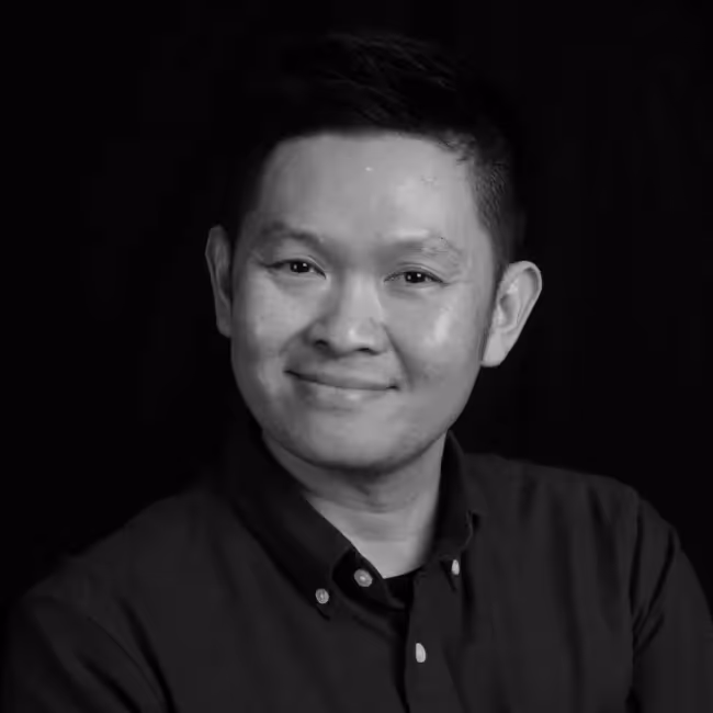benson low headshot - black and white photo of man with short dark hair smiling