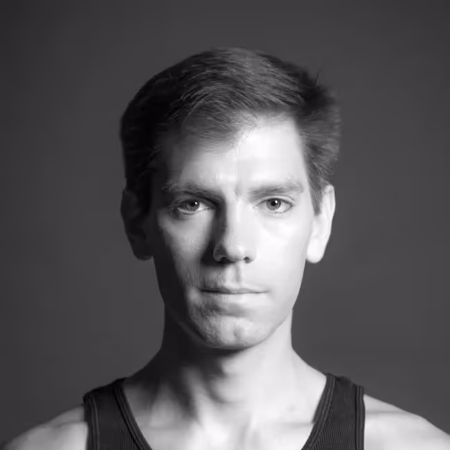 brad orego headshot - black and white photo of man with short brown hair in dark tank top against black background