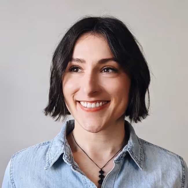 erica ellis headshot - woman with short dark hair against a gray background