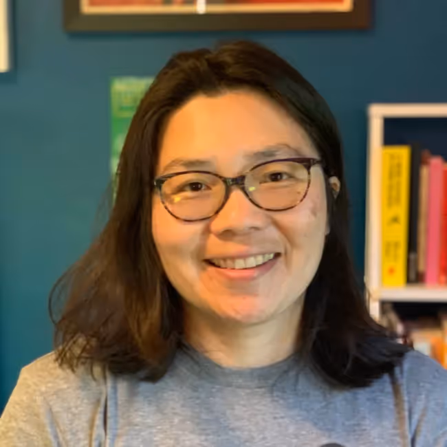 michelle chin headshot - woman with shoulder length dark hair and glasses in gray shirt 