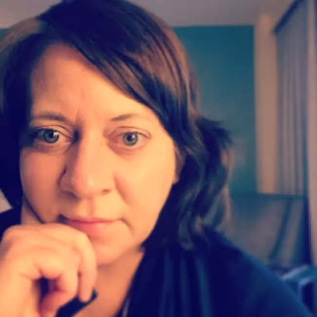 rachael Dietkus headshot - woman with short brown hair against a dark blurred background