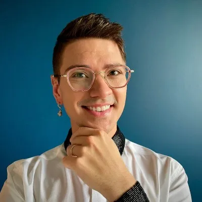 Headshot for Devin Harold, a smiling man with brown hair and clear rimmed glasses