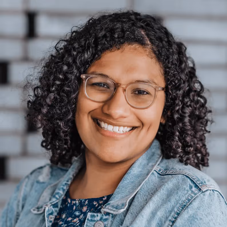 Headshot of Roberta Dombrowski, a woman with dark curly short hair and glasses. Link goes to their LinkedIn profile.