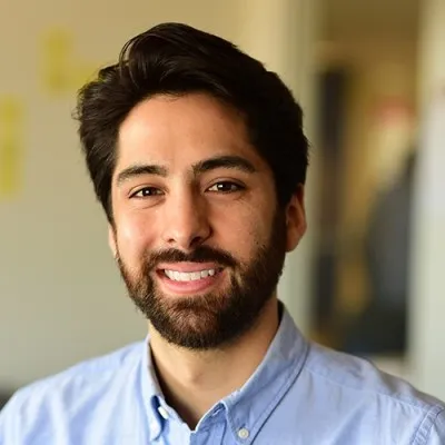 Headshot of Paolo Appley wearing a blue button up shirt