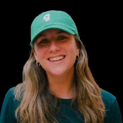 Headshot photograph of Kirsty Finlayson wearing a hat with a black background