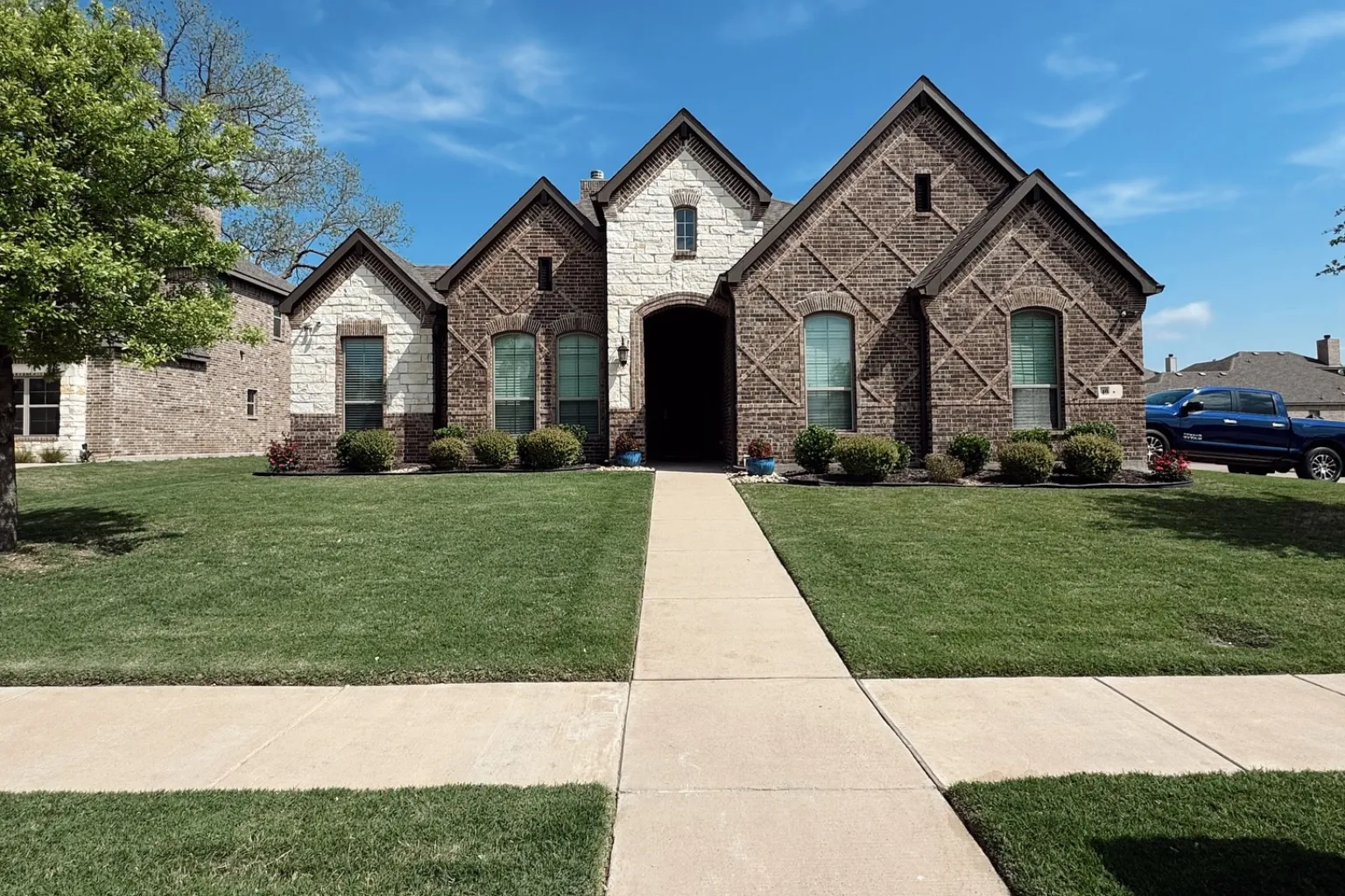 Vista Lawn and Pest technician applying fertilizer treatment to a residential lawn in North Texas