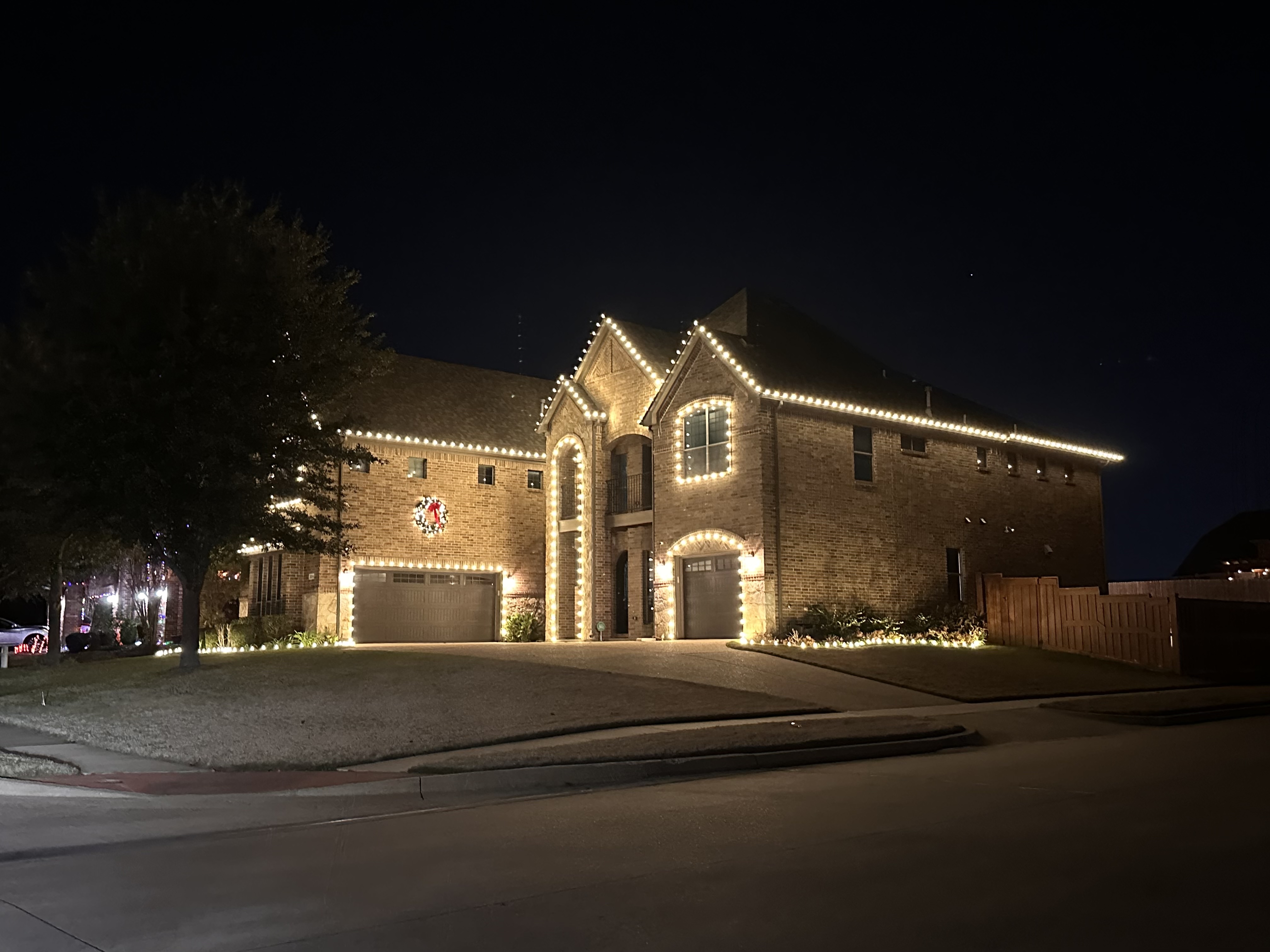 Professional holiday light installation on a brick home in North Texas by Vista Lawn and Pest