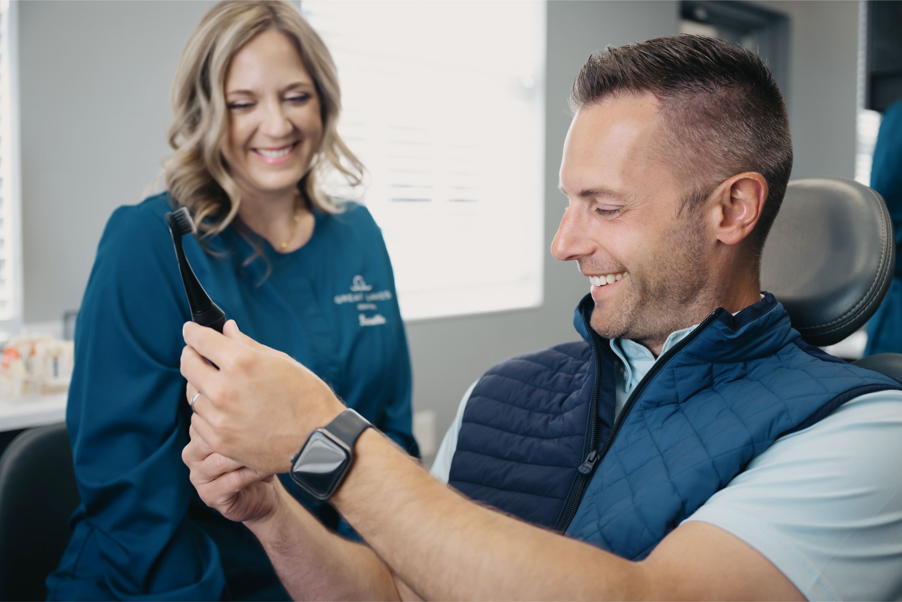 A doctor at Great Lakes Dental showing the patient his teeth