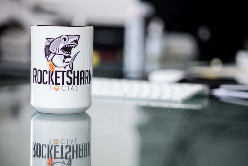 image of a coffee cup on a desk, with logo of rocketshark social
