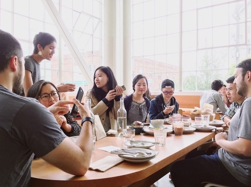 A team of designers gathered around a table for breakfast.