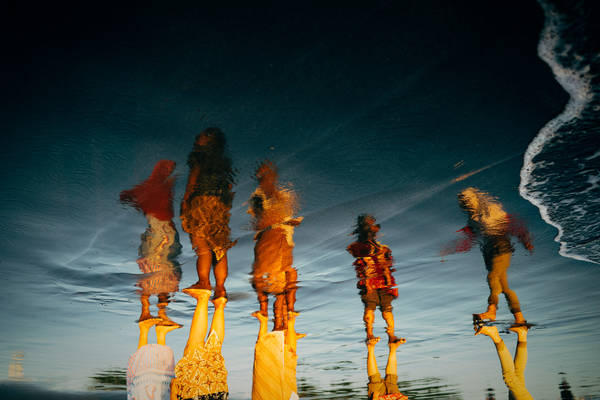 Low Section Of People Standing At Beach During Sunset