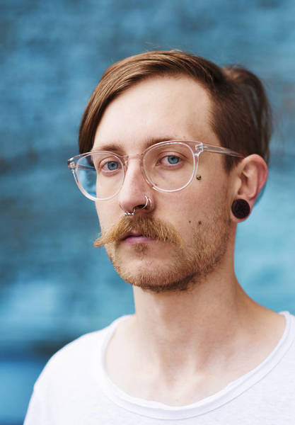 PORTRAIT OF YOUNG MAN WEARING EYEGLASSES
