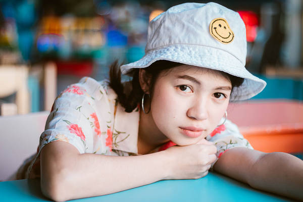 Portrait Of Young Woman Wearing Hat Lying On Table