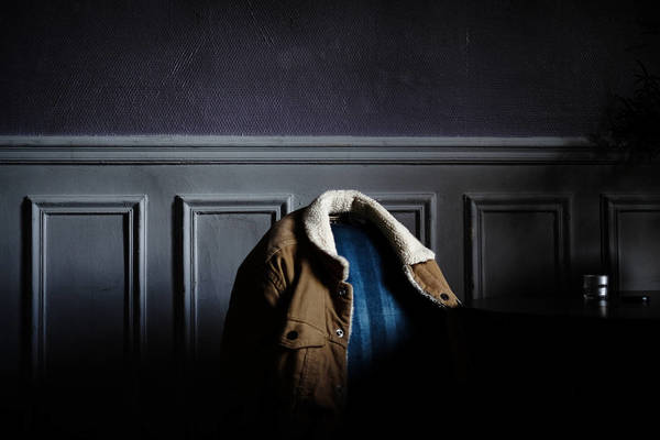 Close-Up Of Jacket On Chair Against Wall At Home
