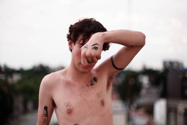 Shirtless Man Showing Tattoo On Hand