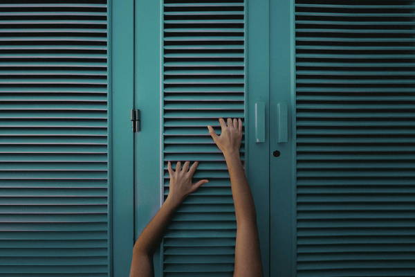 CLOSE-UP OF HUMAN HAND on shutters