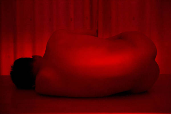 Rear View Of Naked Man Lying On Table In Room
