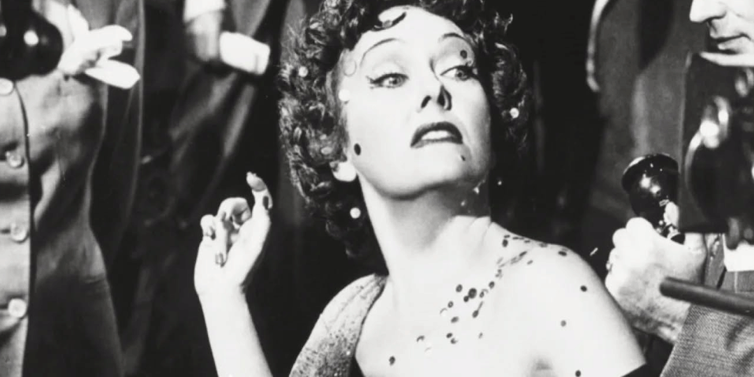 Black and white still from the film Sunset Boulevard with Norma Desmond looking down her nose