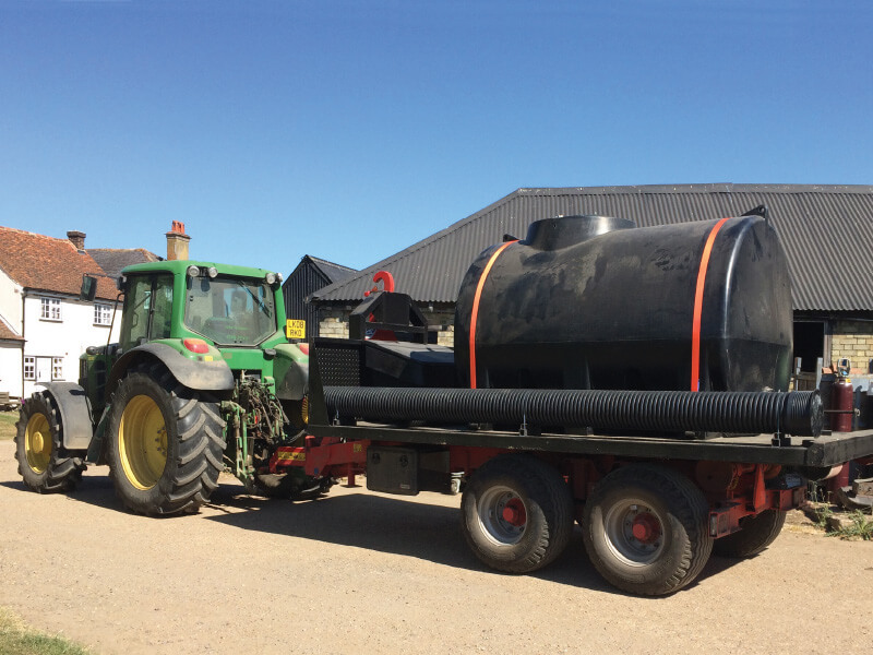 A Liquid Transport Tank being used to transport water in an agricultural setting