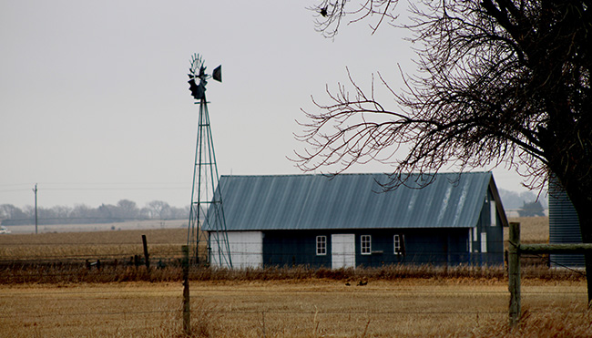 Barn with windmill in foreground.