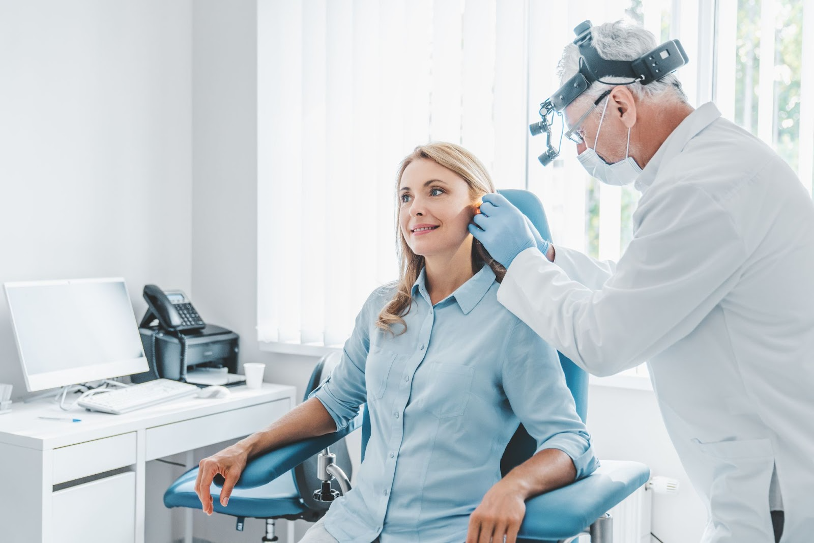 Doctor examining woman’s ear during ENT appointment