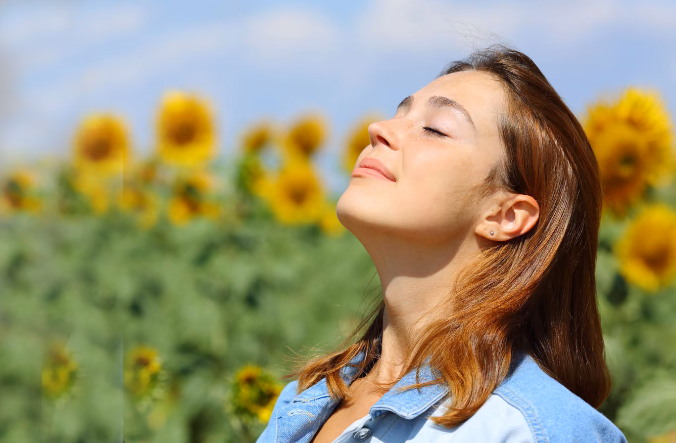 Woman sneezing into tissue outdoors