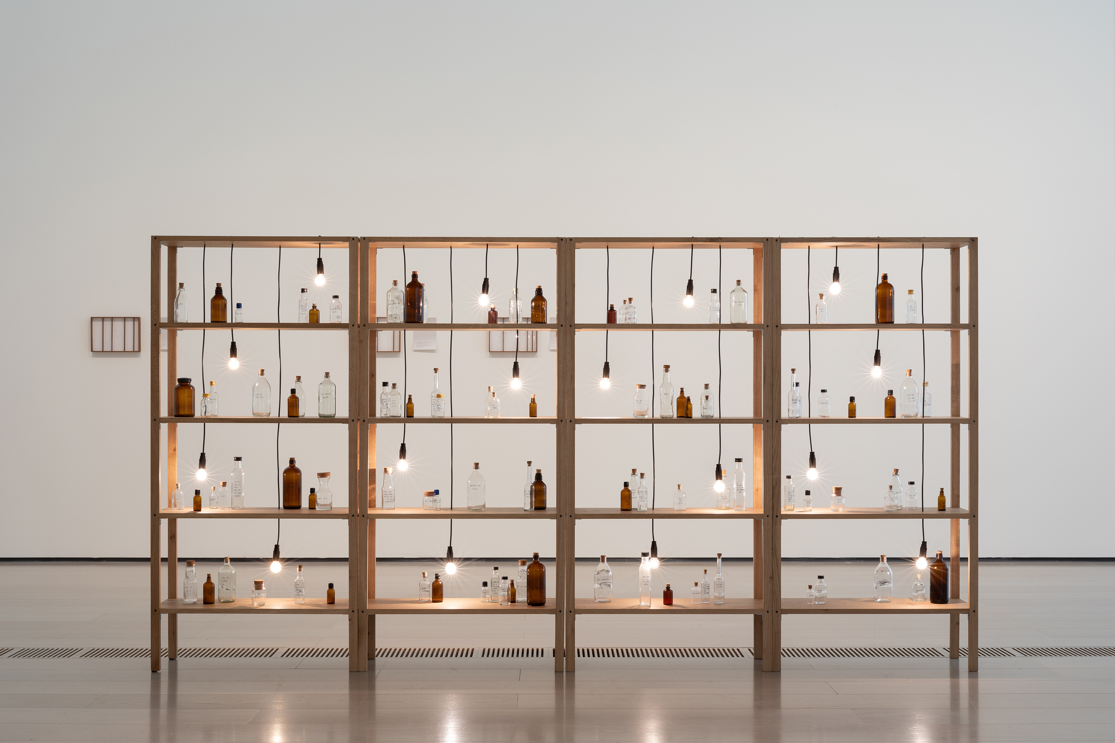Shilpa Gupta, Untitled (Spoken Poem in a Bottle), 2018- laufend, Holz, Glasflaschen, Glühbirnen, 174 x 331.5 x 30.5 cm, courtesy the artist and neugerriemschneider, Berlin, Foto: Vicente Paredes, © Shilpa Gupta