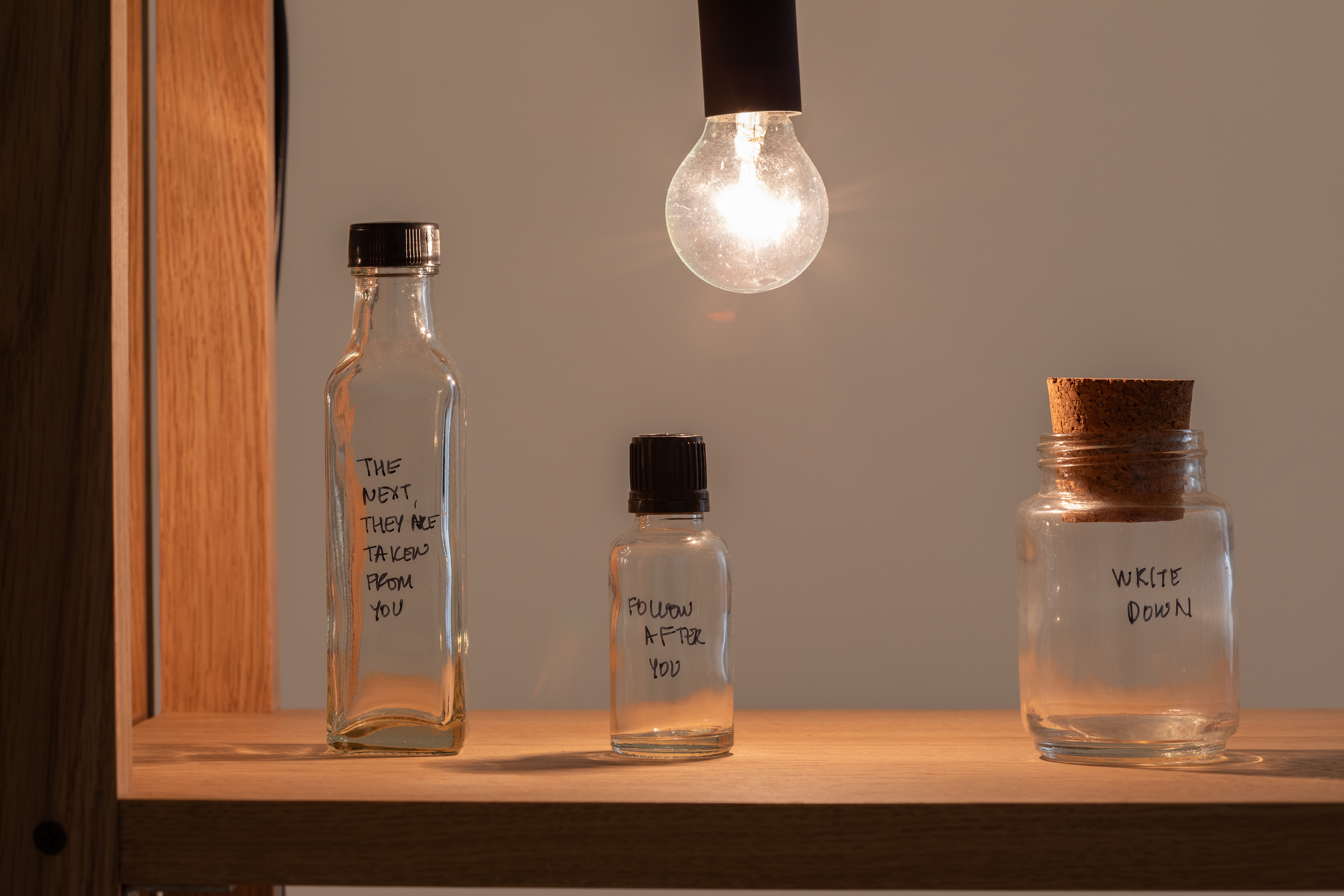 Shilpa Gupta, Untitled (Spoken Poem in a Bottle), 2018- laufend, Holz, Glasflaschen, Glühbirnen, 174 x 331.5 x 30.5 cm, courtesy the artist and neugerriemschneider, Berlin, Foto: Vicente Paredes, © Shilpa Gupta