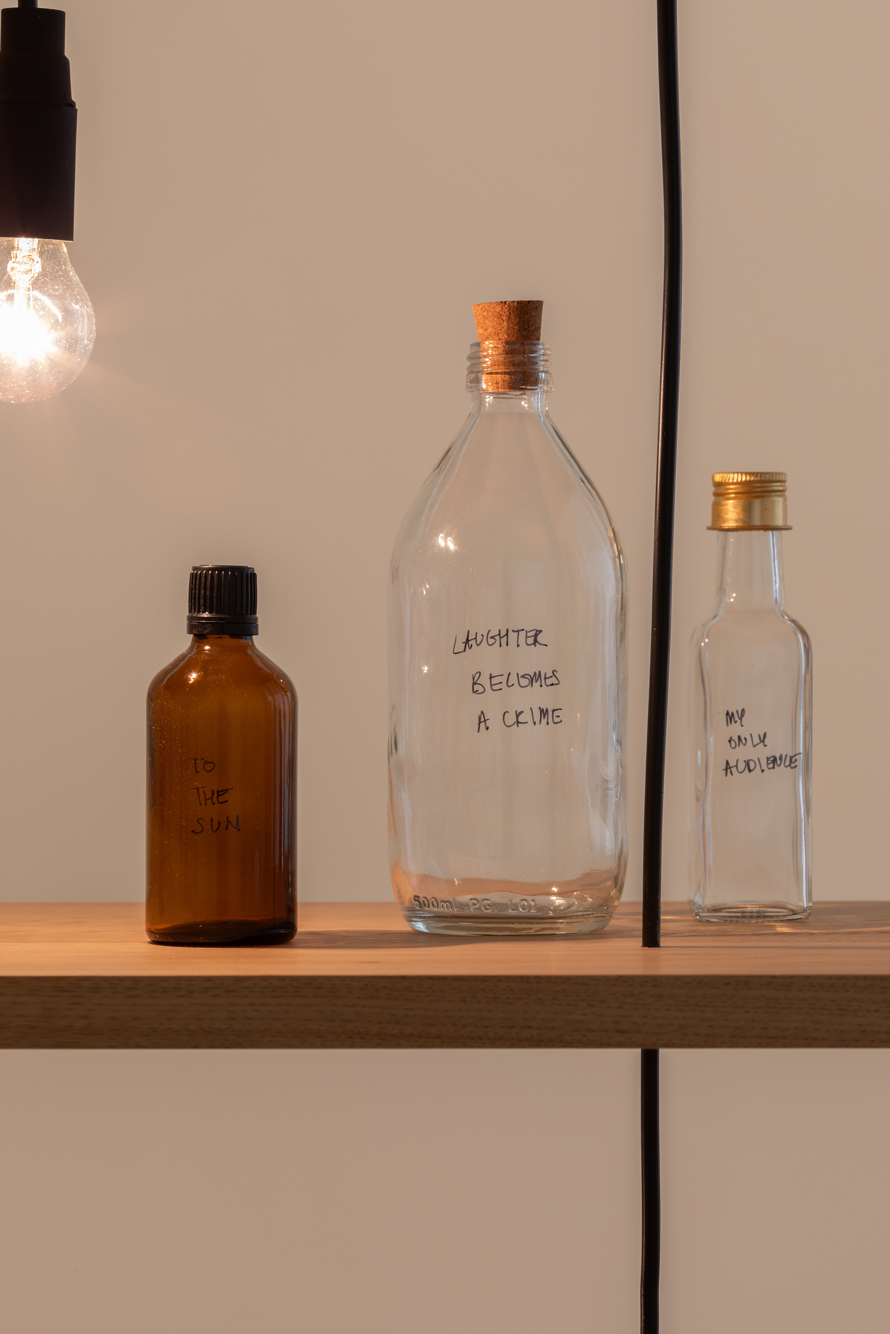 Shilpa Gupta, Untitled (Spoken Poem in a Bottle), 2018- laufend, Holz, Glasflaschen, Glühbirnen, 174 x 331.5 x 30.5 cm, courtesy the artist and neugerriemschneider, Berlin, Foto: Vicente Paredes, © Shilpa Gupta