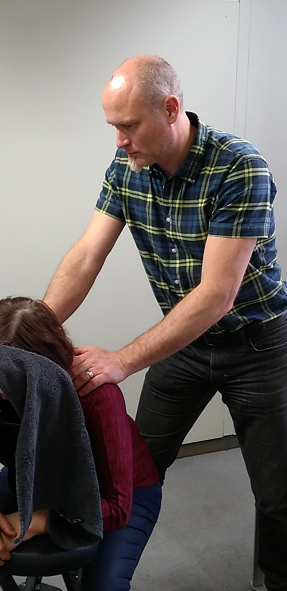 massage therapist giving chair massage to a client