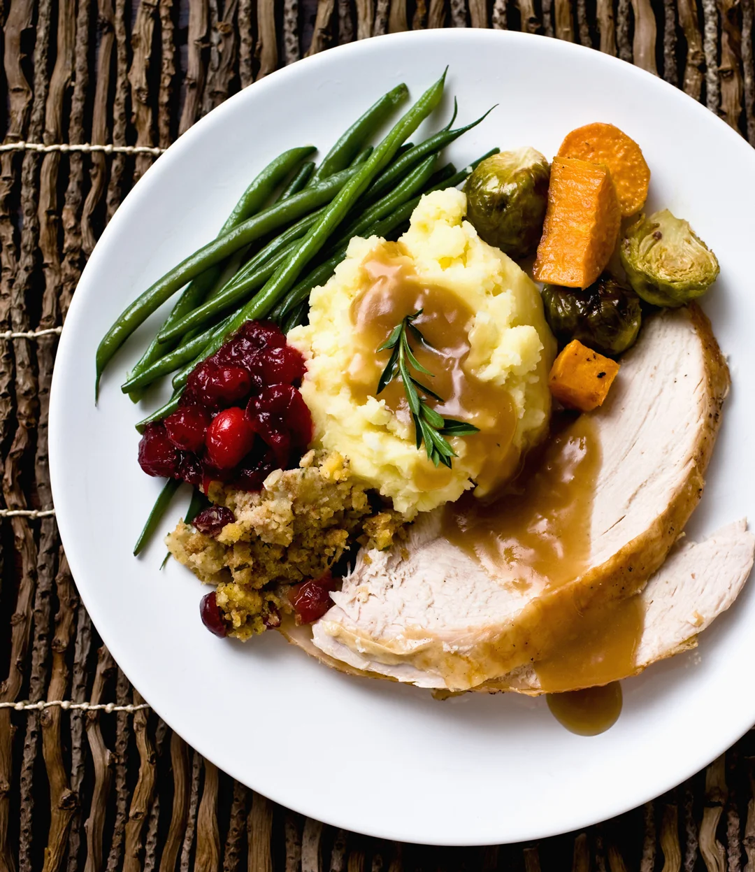 Thanksgiving plate with turkey, mashed potatoes, gravy, vegetables, and stuffing