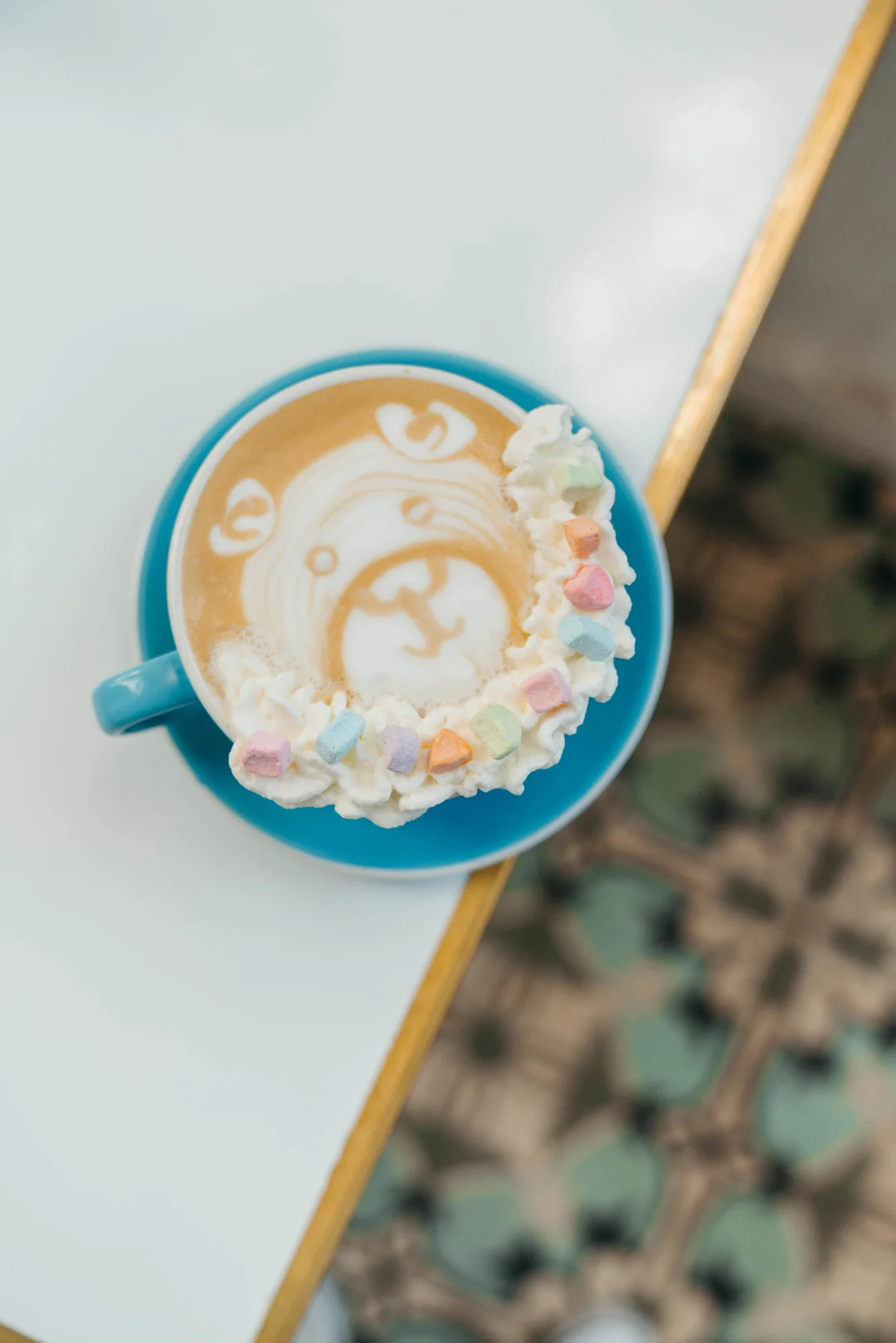 Hot latte with bear foam art, whipped cream and pastel marshmallows