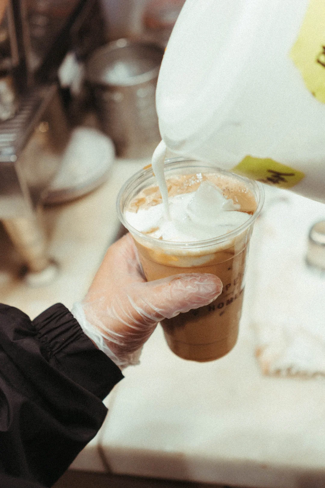Milk being poured over ice and espresso