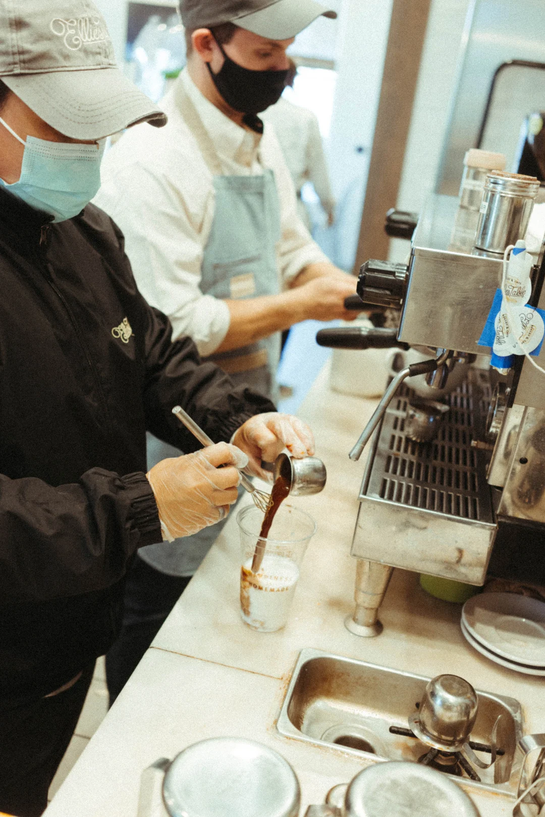 Leena assembling an iced latte at the café counter
