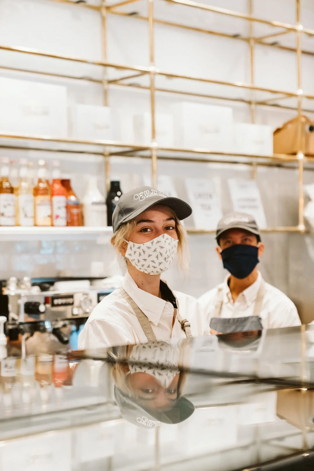 Two masked employees behind the Ellie’s Table pastry counter