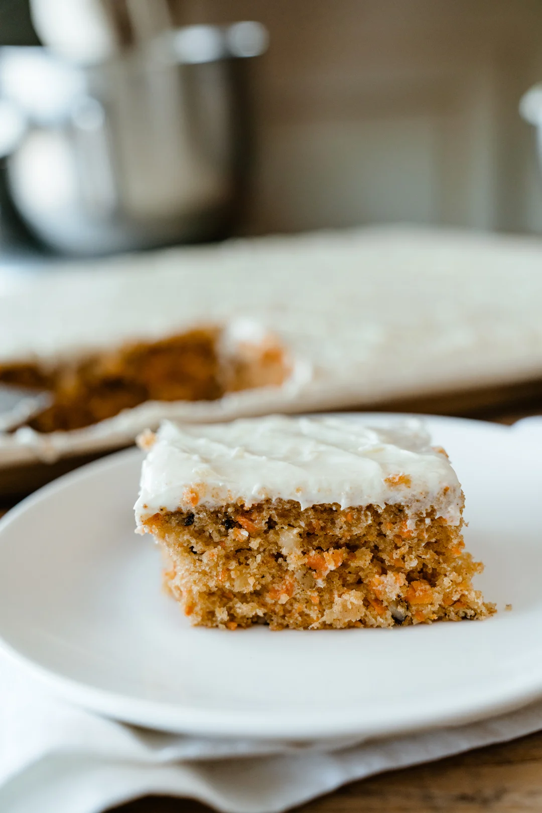Close view of a frosted carrot cake slice