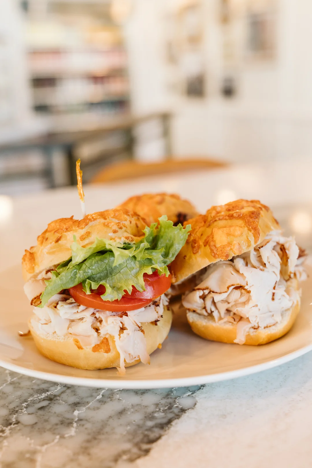 Three turkey sandwiches on cheese rolls with lettuce and tomato