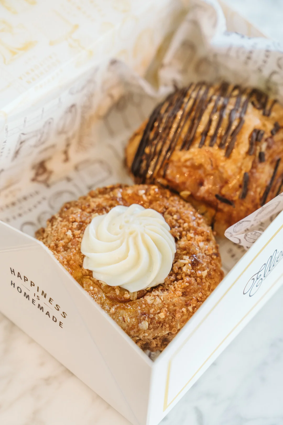 Bakery box with crumb cake and chocolate-drizzled pastries