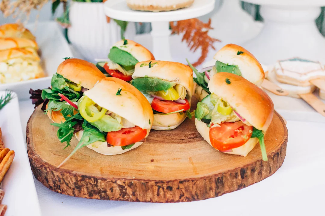 Mini sandwiches arranged on a wooden serving slab
